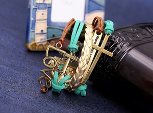 Dettaglio macro del bracciale multistrato in pelle PU intrecciata con ciondoli LOVE