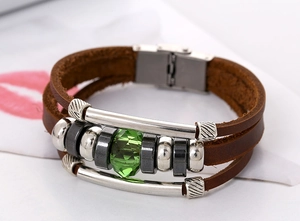 Close-up of vintage multi-layer brown leather bracelet with green faceted crystal bead