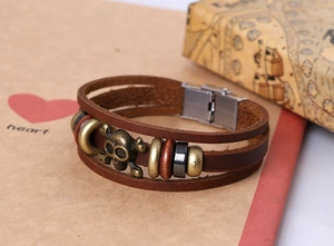 Close-up of brown multilayer leather bracelet with bronze skull and magnetic clasp