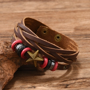 Detail of vintage woven leather bracelet featuring a bronze star and colorful beads