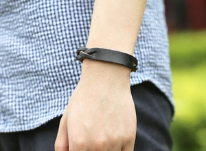 Vue détaillée d'un bracelet en cuir noir tressé à la main au poignet pour un style vintage