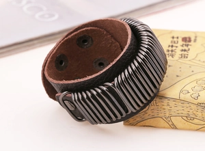 Macro shot of punk wide leather bracelet with metal coils and snap button closure