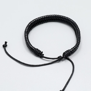 Close-up of black braided leather bracelet featuring adjustable pull-string closure detail