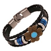 Close-up of vintage multi-layer braided leather bracelet with floral charm and metal clasp