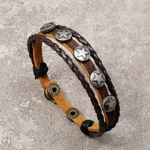 Detail of vintage leather bracelet with metal star rivets and braided cord straps