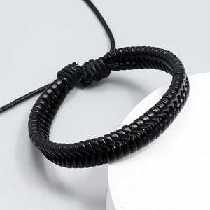 Detail of hand-woven black leather bracelet with adjustable cord and textured finish