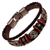 Macro detail of men's vintage brown braided leather bracelet with silver punk cross charms