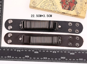 Detail of two-piece black punk leather bracelets with metal coils and silver snaps