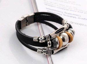 Macro detail of multi-layer leather bracelet featuring alloy beads and magnetic clasp