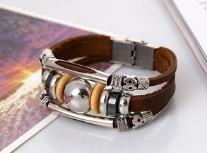Close-up of vintage multilayer braided brown leather bracelet with silver beads and wood accents