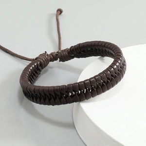 Detail view of deep brown hand-woven leather bracelet with adjustable drawstrings