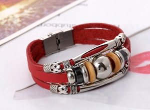 Macro detail of multilayer red leather bracelet featuring silver beads and metal buckle