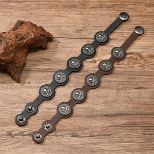 Détail de bracelets en cuir vintage avec clous en métal tête de mort et fermoir