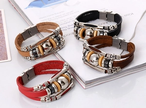 Detail of four-piece braided leather bracelets with stainless steel clasps and wood beads