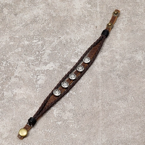 Detail of adjustable snap closure and five-star metal studs on brown leather bracelet