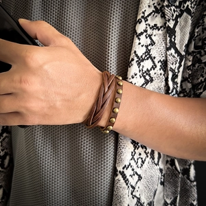 Close-up of men's vintage multi-layer braided leather bracelet with round metal studs