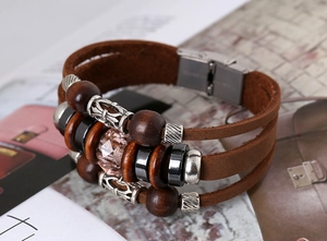 Detail of bohemian multilayer brown leather bracelet with wood beads and pink crystal