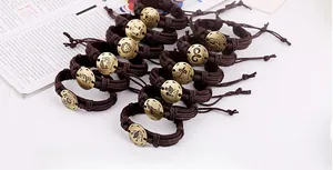 Close-up of 12 zodiac multi-layer braided leather bracelets with bronze constellation charms