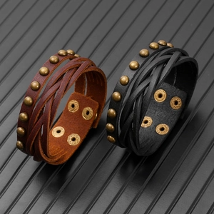 Detail of multi-layer woven leather bracelets with vintage bronze rivets and snap buttons