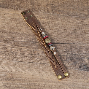 Detail of brown litchi pattern leather bracelet with sun motif and vintage beads