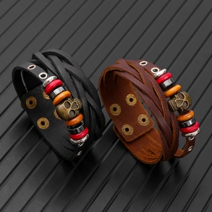 Close-up of vintage multi-layer leather bracelets with skull charms and metallic rivets
