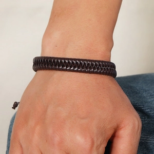 Close-up of men's dark brown hand-woven leather bracelet with adjustable drawstring