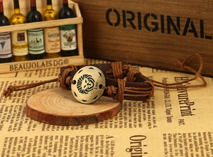Macro view of vintage brown leather woven bracelet with bronze Leo zodiac metal charm