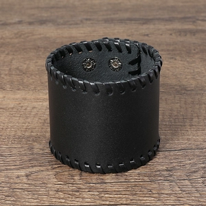 Detail of black punk leather wristband featuring whipstitch edges and silver metal snaps