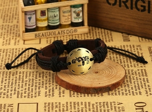 Close-up of vintage leather braided bracelet with brass Virgo sign and adjustable cord