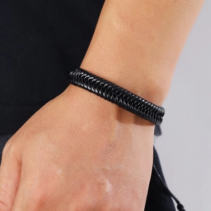 Detailed close-up of a handmade braided black leather punk bracelet with adjustable cord