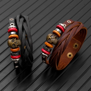 Retro multi-layer leather bracelets with skull charm and wood beads on black texture