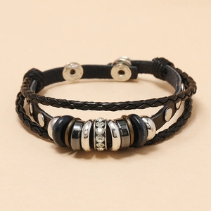 Detail of multilayer black leather bracelet featuring woven straps and rhinestone bead