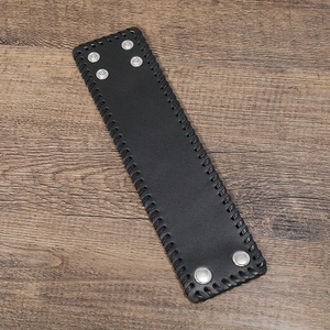 Detail of black wide leather punk bracelet with braided edges and silver metal snaps