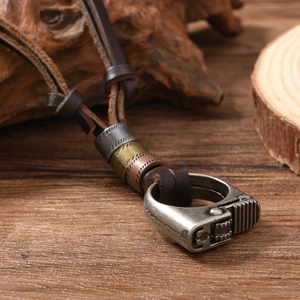 Detail of vintage lighter-shaped alloy pendant on brown leather cord with metal beads