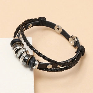 Detail of multi-layer black leather bracelet with silver beads and rhinestone ring charm