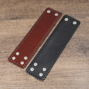 Detail of punk style wide leather bracelets in black and brown with braided edges