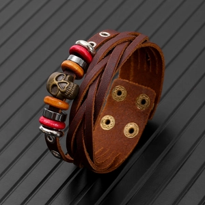 Detail view of vintage multi-layer braided leather bracelet with bronze skull and beads