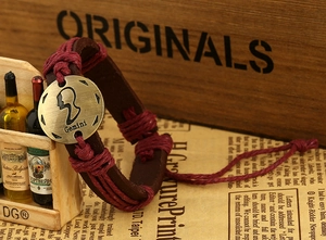 Detailed macro of the Gemini zodiac vintage leather bracelet on a retro background
