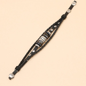 Detail of black multilayer braided leather bracelet with metal studs and snap closures