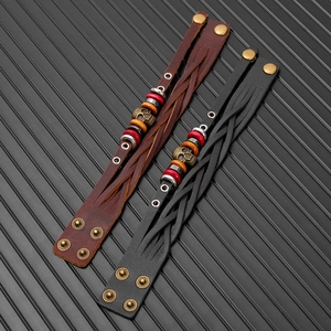 Detail of vintage skull charms on multi-layer braided leather bracelets for men