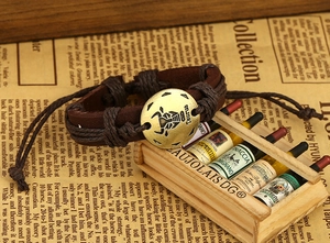 Detail of retro leather Taurus zodiac bracelet with braided ropes on vintage paper