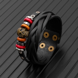 Detail view of woven leather bracelet featuring a vintage bronze skull and colorful beads