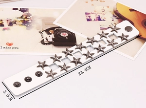 Dettaglio del bracciale punk in pelle bianca con borchie a stella e misure