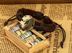 Detail of vintage Scorpio braided leather bracelet with round bronze zodiac pendant charm