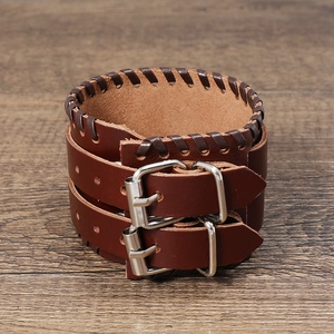 Mehrlagiges Retro-Lederarmband in Braun mit silberner Schließe auf einem Holzhintergrund