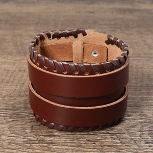 Nahaufnahme des braunen Lederarmbands mit geflochtenen Kanten und Metalldruckknopf