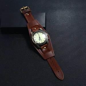 Detail view of vintage brown leather Bund watch strap with antique bronze metal buckle