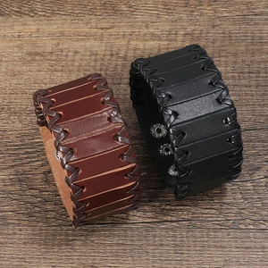 Detail of multilayer punk leather bracelets in black and brown with braided edge finish