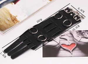 Detalle de muñequera punk de cuero negro con anillos metálicos y hebillas de triple correa