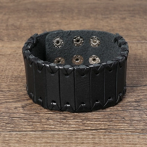 Detail of wide black braided leather bracelet with silver adjustable metal snap buttons